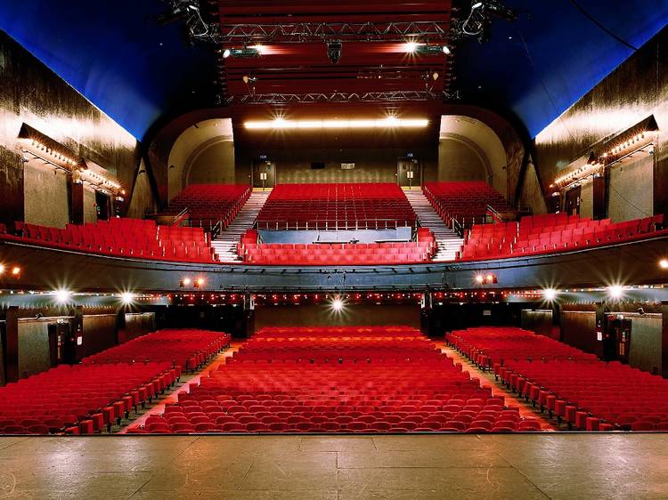 Photo montrant la salle "l'Acoustique", depuis la scène avec ses chaises rouges et ses balcons