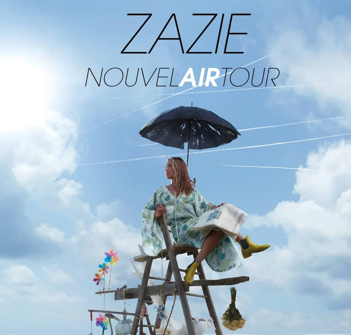 Zazie assise sur une chaise avec un parasol avec un fond sur le ciel, pour son affiche de concert